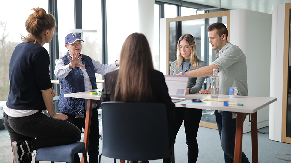 Agiles Delivery Team im Gespräch am Tisch.